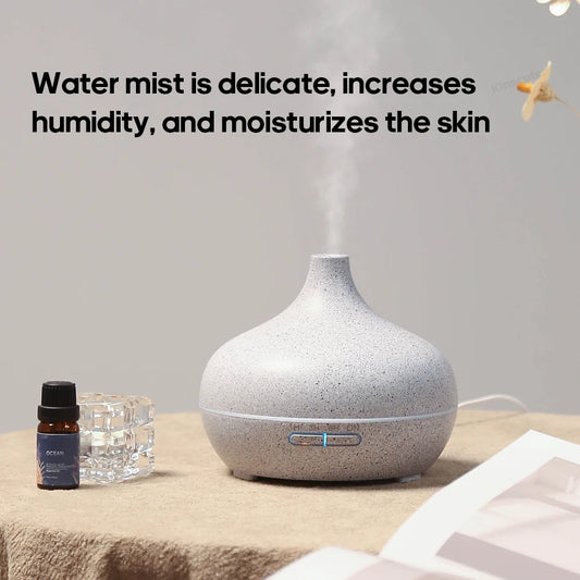 Diffuseur d'huiles essentielles en bois clair diffusant une brume légère sur une tablette de salle de bain