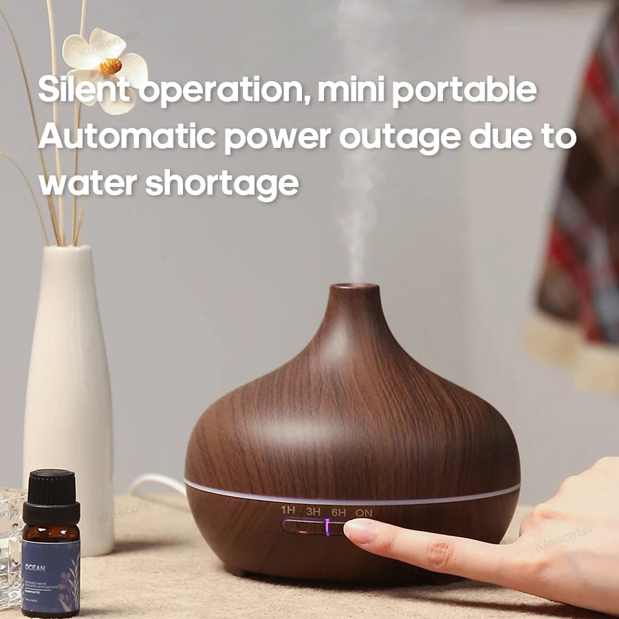 Diffuseur d'huiles essentielles en bois clair diffusant une brume légère sur une tablette de salle de bain